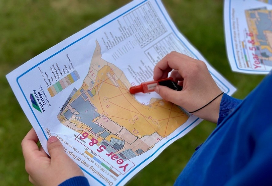 Student drawing on a map as part of orienteering