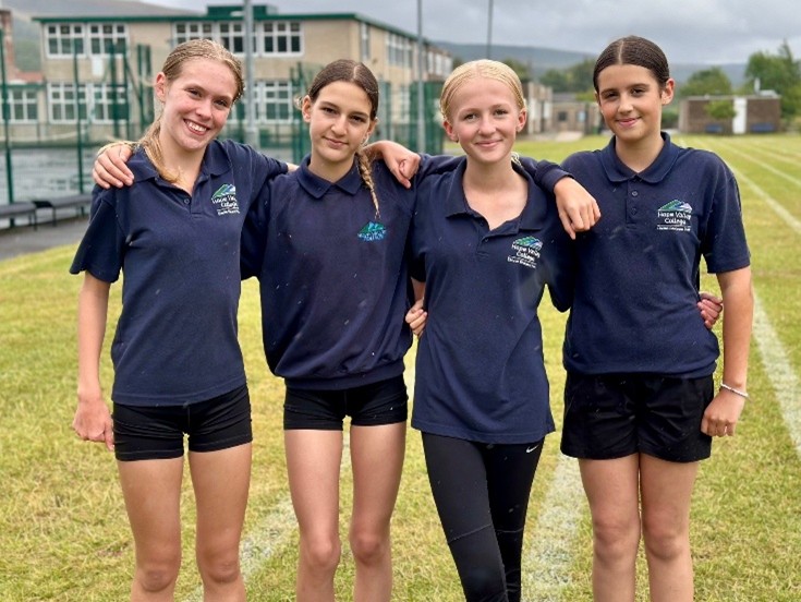 Four members of the Athletics Club standing and smiling