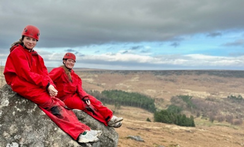 Two students sitting on a rock at Higger Tor
